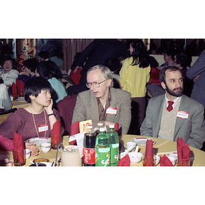 Lydia Lowe chats with two men at a restaurant table during Chinese Progressive Association's celebration of the Chinese New Year