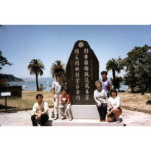 Chinese Progressive Association members sit around a Chinese monument at Angel Island Immigration Station, during a trip to San Francisco
