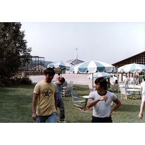 Two men converse while walking through an outdoor eating area