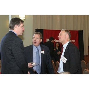 Three men stand and converse at the Training Future Innovators Entrepreneurs Panel