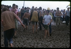Concert-goers trudging through the mud at the Woodstock Festival