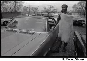 Umoja (Black student union) activist standing by car, wrapped in a sheepskin, at site of occupied administration building, Boston University