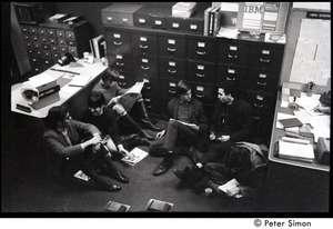 Students seated in front of filing cabinets during occupation of the University Placement Office, Boston University, to protest on-campus recruiting by Dow Chemical Co.