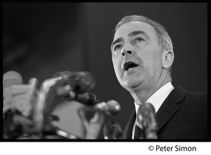 Presidential candidate Eugene McCarthy behind a bank of microphones, giving a speech at Boston University