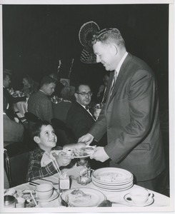 Willis C. Gorthy handing plate to a young client at Thanksgiving party