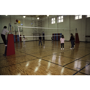Children and adults setting up for a volleyball game