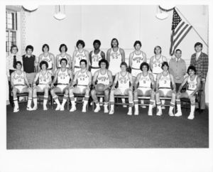 Suffolk University men's basketball, team photograph, Chris Tsiotos (#33) is front row, center, holding a basketball, 1977