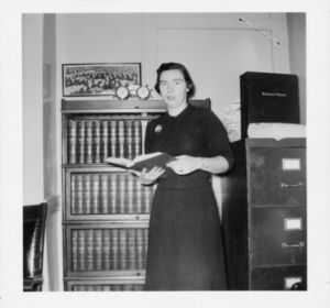 Suffolk University Trustee Jeanne M. Hession (JD 1956) standing, holding an open book