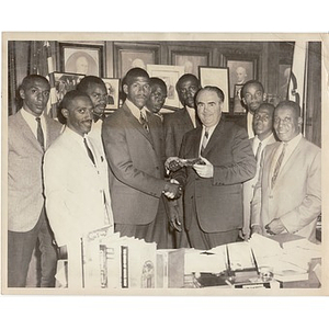 Kivie Kaplan shakes hands with an unidentified male while Reverend Michael E. Haynes looks on