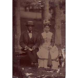 An African American couple outside with an umbrella