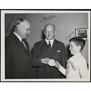 Rudolph F. King, former Speaker of the Massachusetts House of Representatives, presents a Green Cross For Safety patch to Larry Conroy while [Jon?] Bliss looks on