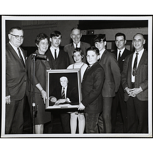 Boys' Club members and staffers standing with a portrait of Nate Hurwitz, former Charlestown Boys' Club director