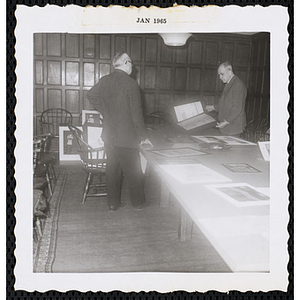 Two Art Selection Committee members Richard H. Bassett, at right, and an unidentified man discuss a painting for the Boys' Clubs of Boston Fine Arts Exhibit at the Amory Coolidge Gallery, Museum of Science