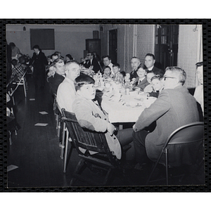 Men and boys pose for a shot at a table during a Dad's Club/Mother's Club banquet