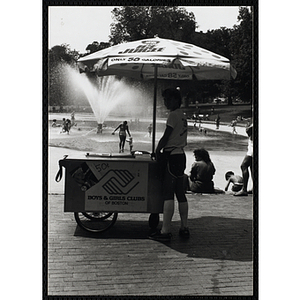 A teenage boy stands next to his ice juice cart on Boston Common