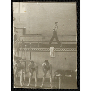 Three teenage boys lean over the edge of pool in Bowdoin College's natorium