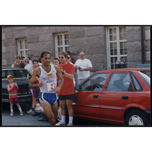 A man runs and is cheered on by spectators during the Bunker Hill Road Race