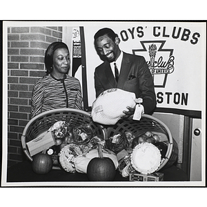 Mrs. James (Rosa) Hunt from the Boston Patriots Wives Association and Mr. Roscoe Baker, Director of the Roxbury Clubhouse at a fund-raising event for the Boys' Clubs of Boston