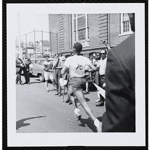 A runner passes spectators as he runs the Roxbury Road Race