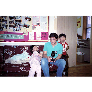 Man and children at the Chinese Progressive Association party celebrating Dynasty Restaurant workers winning their back wages