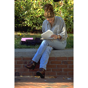 Student doing homework beside Snell Library