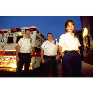 EMTs stand outside an ambulance