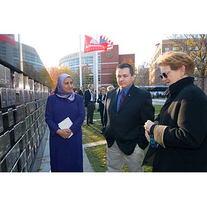 Three people look at the Veterans Memorial during the dedication ceremony