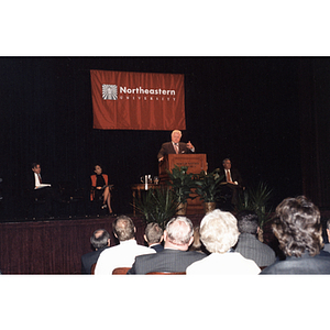 Senator Edward Kennedy speaks from a podium during the Economic Conference at Northeastern