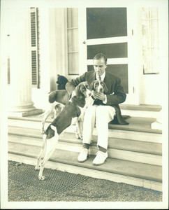 Portrait of Winston Churchill, seated on steps, facing front, with two hound dogs, Cornish, New Hampshire, undated