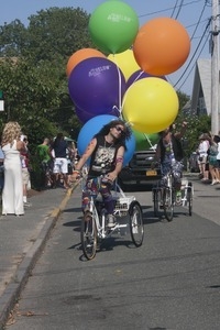 Parade marcher on tricycle, towing large helium balloons : Provincetown Carnival parade