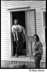 Steve Marsden holding a goat, standing in a doorway, with Verandah Porche, Packer Corners commune