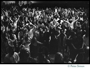 Audience in the Winterland Ballroom raising their arms in ecstasy, listening to Amazing Grace during the Ram Dass 'marathon'