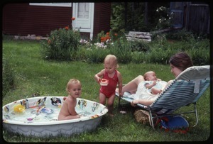 Baby Phoebe Mathews in a wading pool with Janice Frey's family, Montague Farm Commune