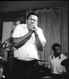 James Cotton at Club 47: James Cotton playing harmonica onstage, with guitarist Luther Tucker partly out of frame at left, and Francis Clay playing drums at right