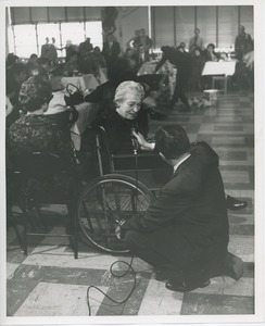 Woman in wheelchair speaking on microphone at Thanksgiving celebration