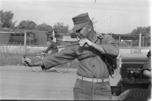 Marine trying Vietnamese slingshot; Danang.