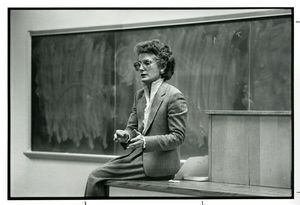 Suffolk University Professor Karen Blum (Law) sitting on a desk while teaching, 1970s