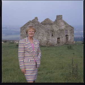 Claire Grimes, owner of the Irish Echo newspaper, New York. Posing at a derelict house, Annalong, Co. Down