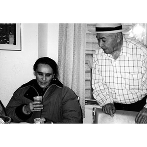 Older man in a hat and another neighborhood resident at a meeting in the Inquilinos Boricuas en Acción offices.