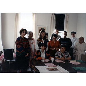 Group portrait of people in the Inquilinos Boricuas en Acción offices at a table covered with flyers.