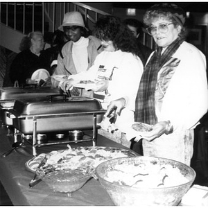 People serving themselves from a buffet table in the Jorge Hernandez Cultural Center.