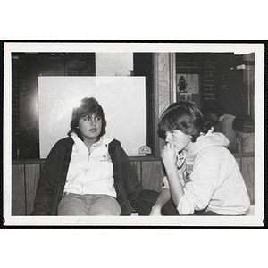 Two teenage girls from the Boys and Girls Clubs of Boston looking in different directions while talking