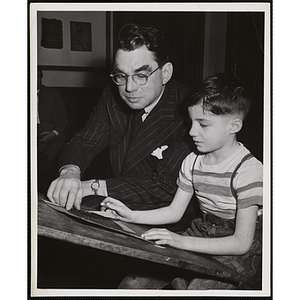 Art Committee member Gardner Cox helps a boy with a drawing at the Boys' Clubs of Boston
