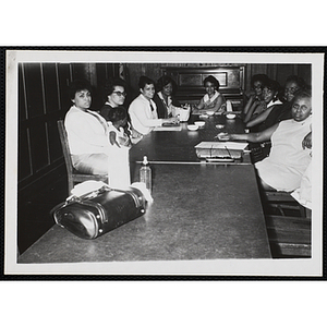 Nine women and a child sit around a conference table at a Mothers' Club meeting