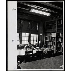 Two boys study at a table in the Charlestown Clubhouse library