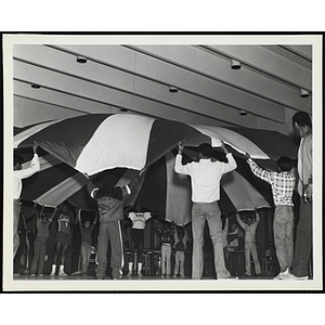 A Large group of African American youth playing a parachute game