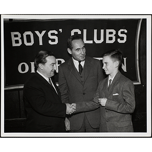 State Senator John E. Powers shaking hands with a boy while Gerald W. Blakeley, Jr. looks on at a Boys' Clubs of Boston awards event