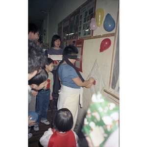 Children laugh as they "pin the tail on the donkey" with balloons, at a Chinese Progressive Association celebration