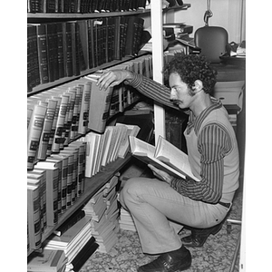 A Northeastern Law School intern pulls books off a shelf