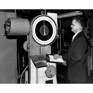 Professor Ralph Sexton works on a machine in an engineering laboratory